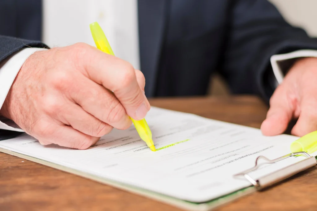 "Person reviewing and highlighting a printed document with a yellow highlighter